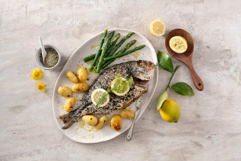 Seabream cooked in the oven with herbs, served with potatoes and garlic