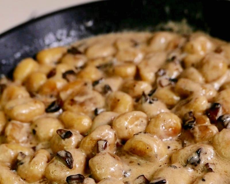 Gnocchi in parmesan sauce with mushrooms and hazelnuts